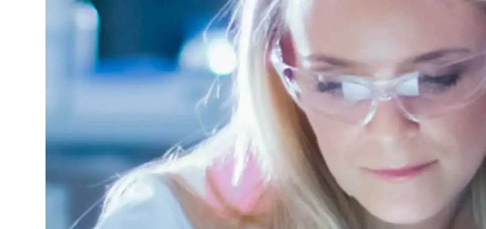 Close-up of the face of a scientist close to her microscope