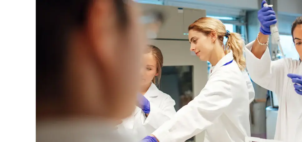 Three young scientists are seen working on a number of vials in the lab