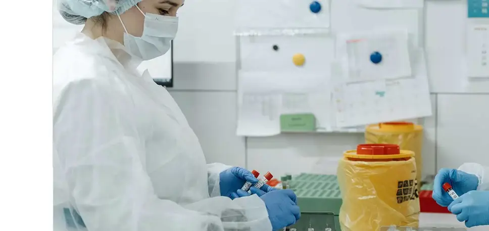 Two scientists working together, holding a set of vials